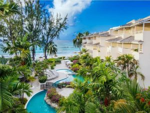 The pool area and gardens of Bougainvillea Barbados with the ocean in the background