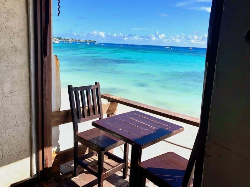 A table with two chairs on a balcony at Surfers Cafe, one of the best restaurants in Oistins