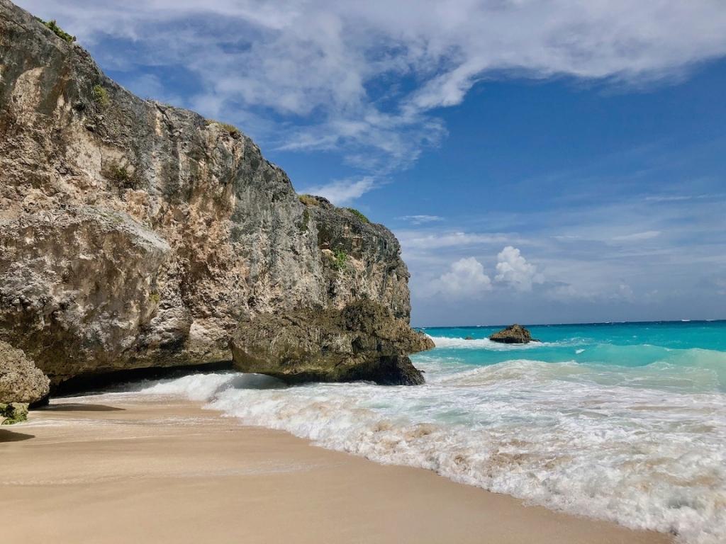 A rock formation surrounded by teal blue water at Bottom Bay in St. Philip Barbados