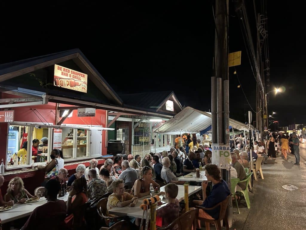 Crowds of people eating outside at the Oistins Fish Fry